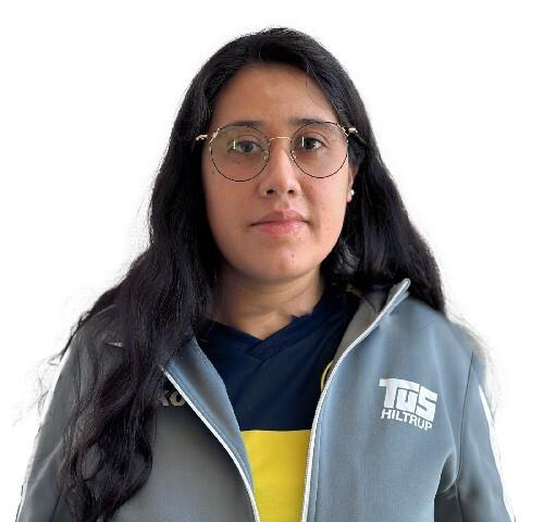 Porträt einer Frau mit langen, schwarzen Haaren, Brille und Sportjacke des TUS Hiltrup auf weißem Hintergrund.