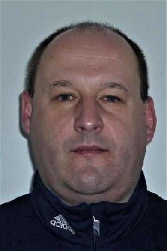 Porträt eines Mannes mit kurzgeschnittenen Haaren, trug einen dunklen Sweatshirt mit Reißverschluss.