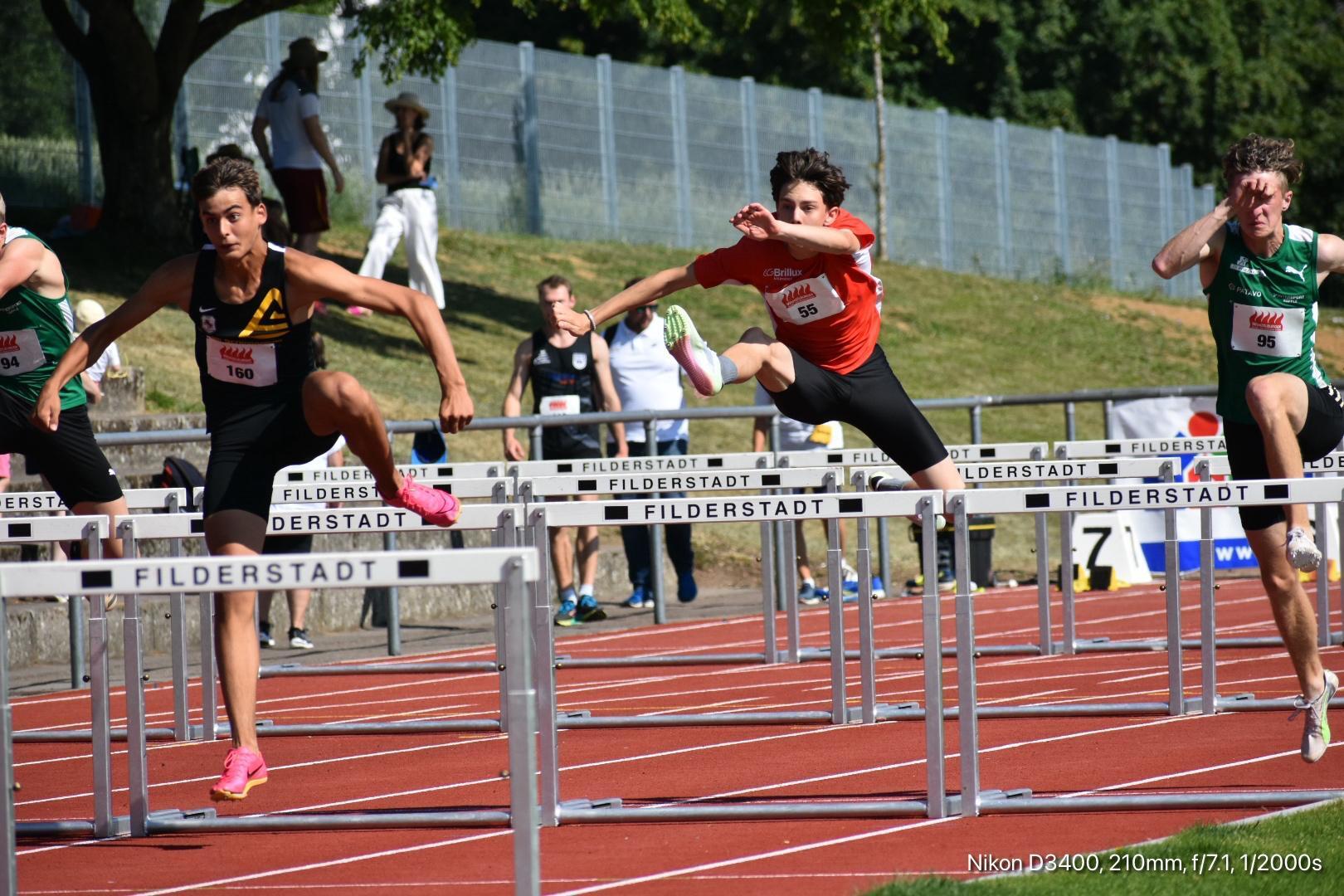 Mehrere Jugendliche springen über Hürden auf einer roten Laufbahn während eines Wettkampfs in Filderstadt.